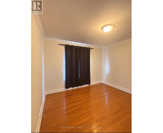 A room with a brown curtain and wooden floor.