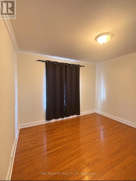 A room with a brown curtain and wooden floor.