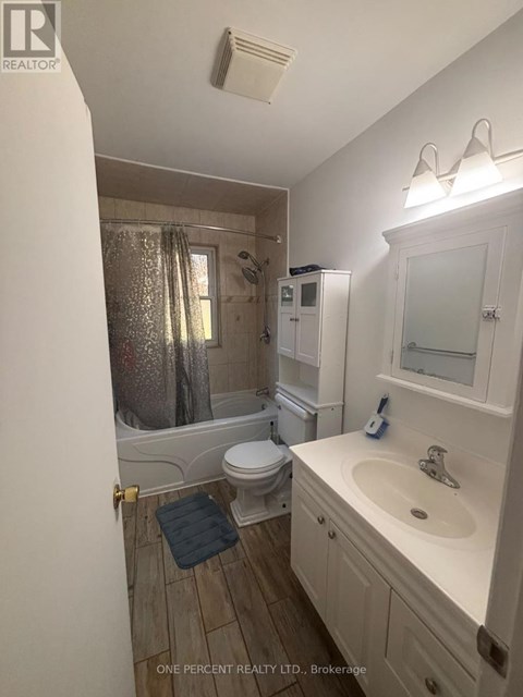 A bathroom with a toilet, sink, and shower.
