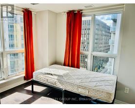 A bedroom with a large bed and red curtains.