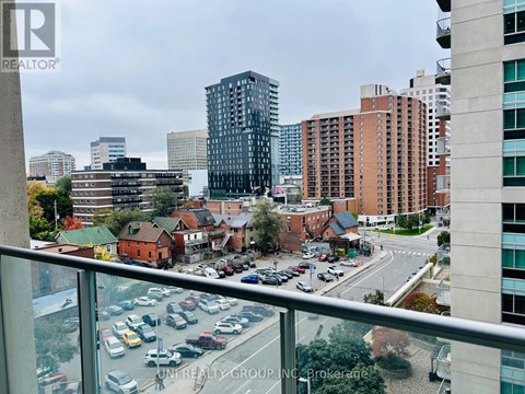 A view from a high-rise building looking down at a busy street with cars and buildings.
