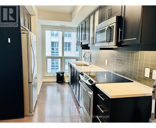 A kitchen with black cabinets and a white countertop.