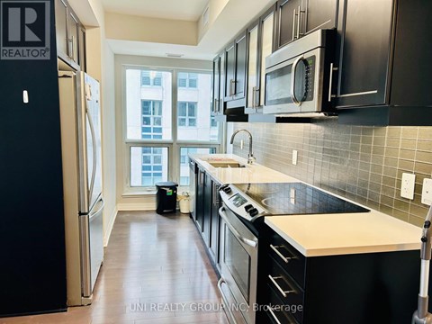 A kitchen with black cabinets and a white countertop.