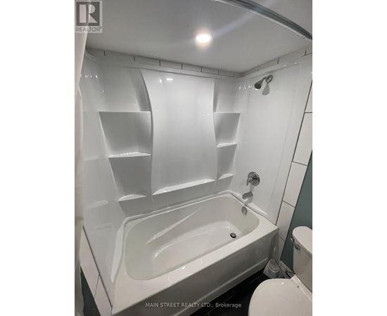 A white bathtub in a bathroom with a shower head.