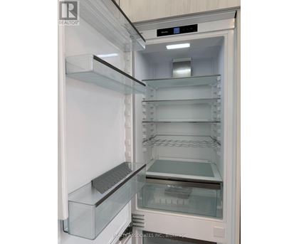 A white refrigerator with the door open and shelves inside.
