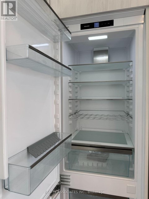 A white refrigerator with the door open and shelves inside.
