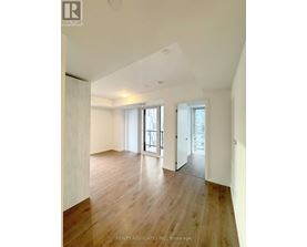 A spacious room with wooden floors and white walls.