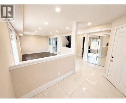 A spacious room with a kitchen area and a tiled floor.