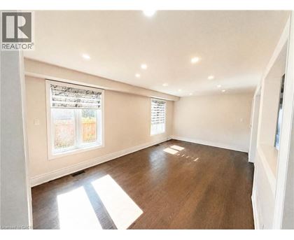 A sunny room with a window and wooden floors.