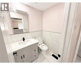 A bathroom with a sink, toilet, and mirror.
