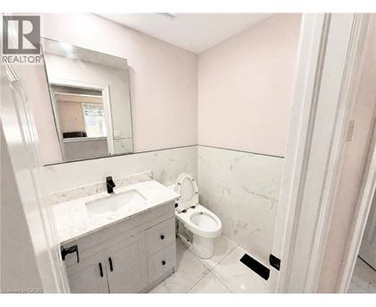 A bathroom with a sink, toilet, and mirror.