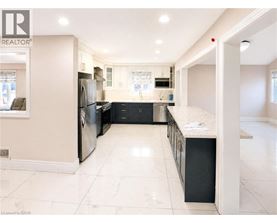 A spacious kitchen with a refrigerator, oven, and sink.