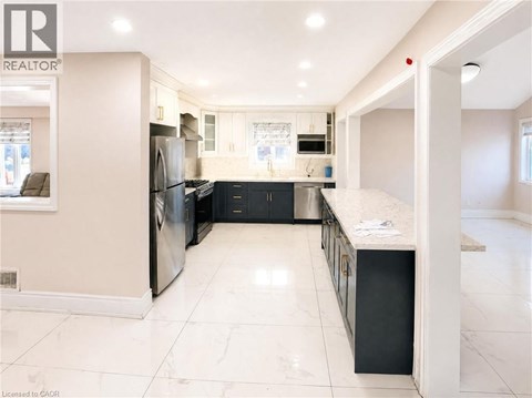 A spacious kitchen with a refrigerator, oven, and sink.
