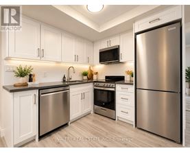 A modern kitchen with stainless steel appliances and white cabinets.
