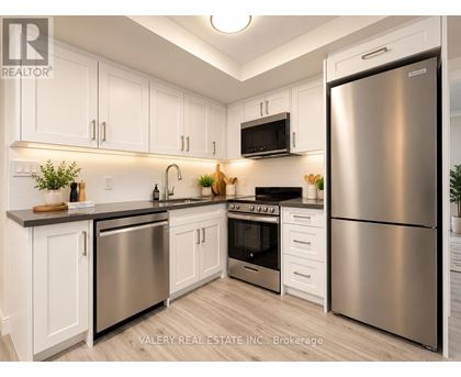 A modern kitchen with stainless steel appliances and white cabinets.