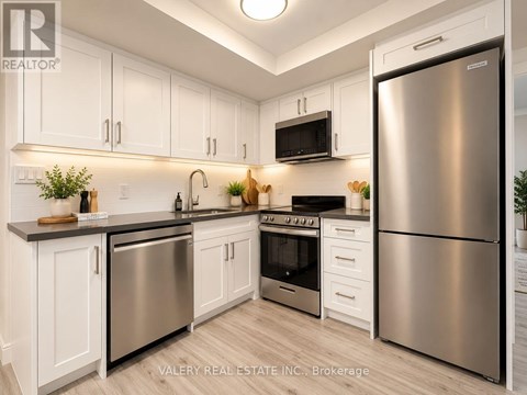 A modern kitchen with stainless steel appliances and white cabinets.