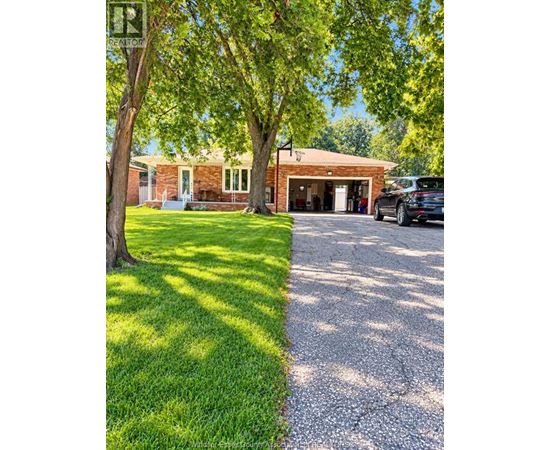 A house with a garage and a car parked in front.