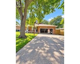 A house with a garage and a tree in front.