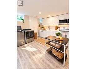 A kitchen with a table and chairs in front of it.