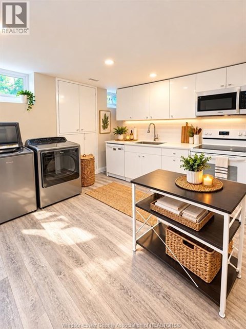 A kitchen with a table and chairs in front of it.