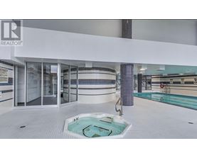 A swimming pool in a room with a glass door.
