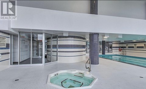A swimming pool in a room with a glass door.