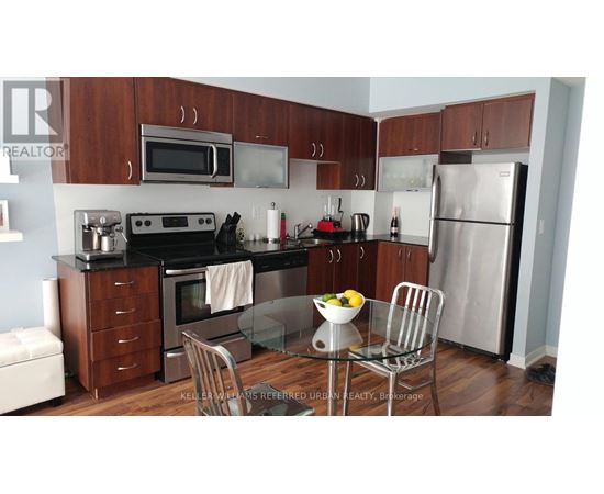 A kitchen with a refrigerator, oven, and microwave.
