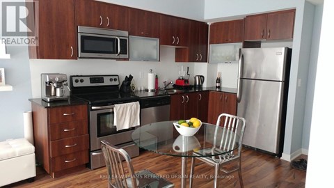 A kitchen with a refrigerator, oven, and microwave.
