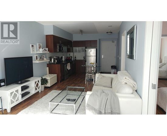 A living room with a white couch and a TV.