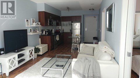 A living room with a white couch and a TV.