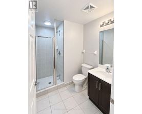 A white bathroom with a toilet, sink, and shower.