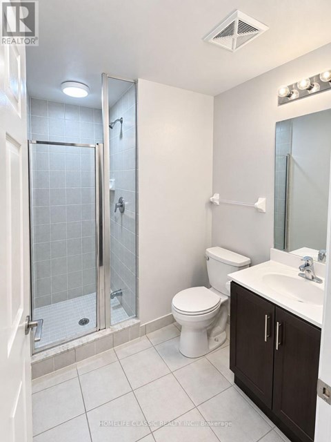 A white bathroom with a toilet, sink, and shower.