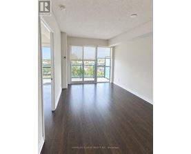 A room with wooden floors and a sliding glass door leading to a balcony.