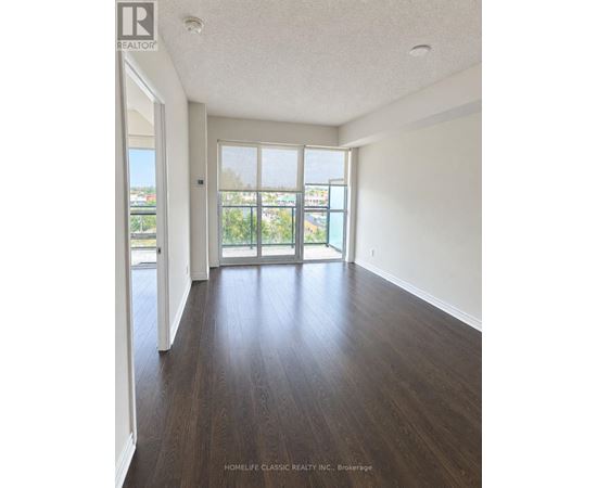 A room with wooden floors and a sliding glass door leading to a balcony.