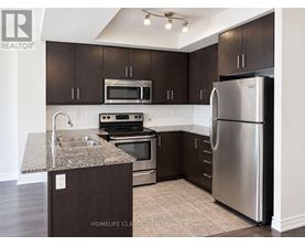A kitchen with dark brown cabinets and stainless steel appliances.