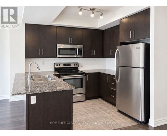 A kitchen with dark brown cabinets and stainless steel appliances.