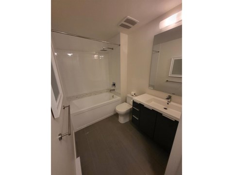 A white bathroom with a toilet, sink, and bathtub.