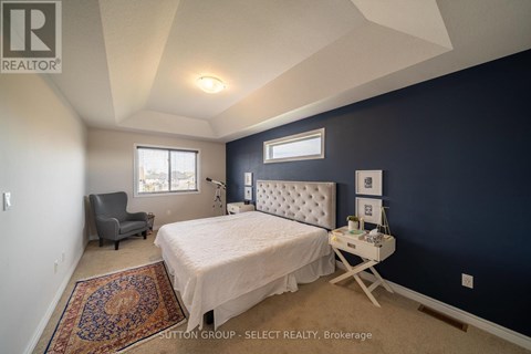 A bedroom with a bed, chair, and window.