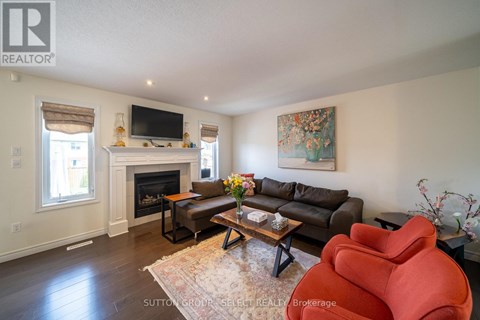 A living room with a fireplace and a flat screen TV mounted on the wall.