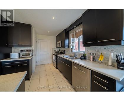 A kitchen with black cabinets and a white countertop.
