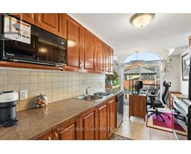 A kitchen with wooden cabinets and a black microwave.