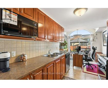 A kitchen with wooden cabinets and a black microwave.