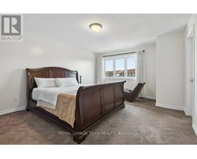 A bedroom with a large bed and a window overlooking a residential area.