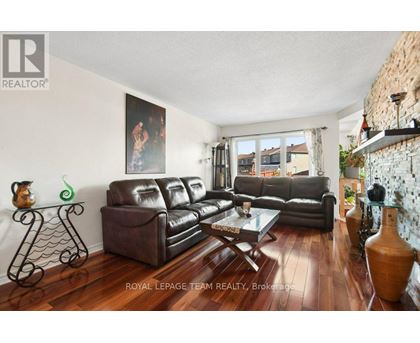 A living room with a large painting on the wall and a leather sofa.