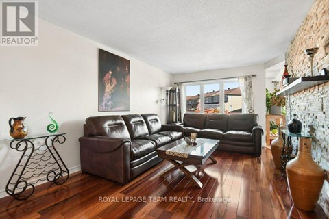A living room with a large painting on the wall and a leather sofa.