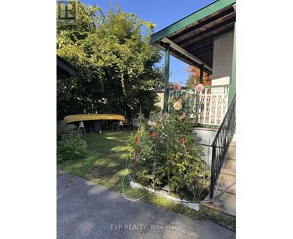 A small garden with a fence and a yellow object in the background.