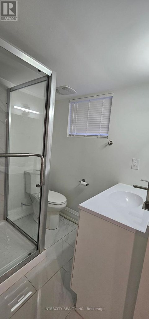 A bathroom with a toilet, sink, and shower.