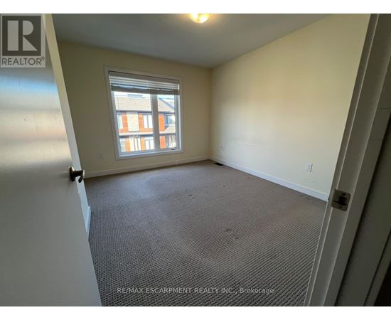 A room with a window and a carpeted floor.
