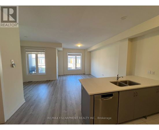 A kitchen with a sink and cabinets in a room with a window.
