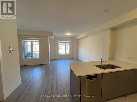 A kitchen with a sink and cabinets in a room with a window.